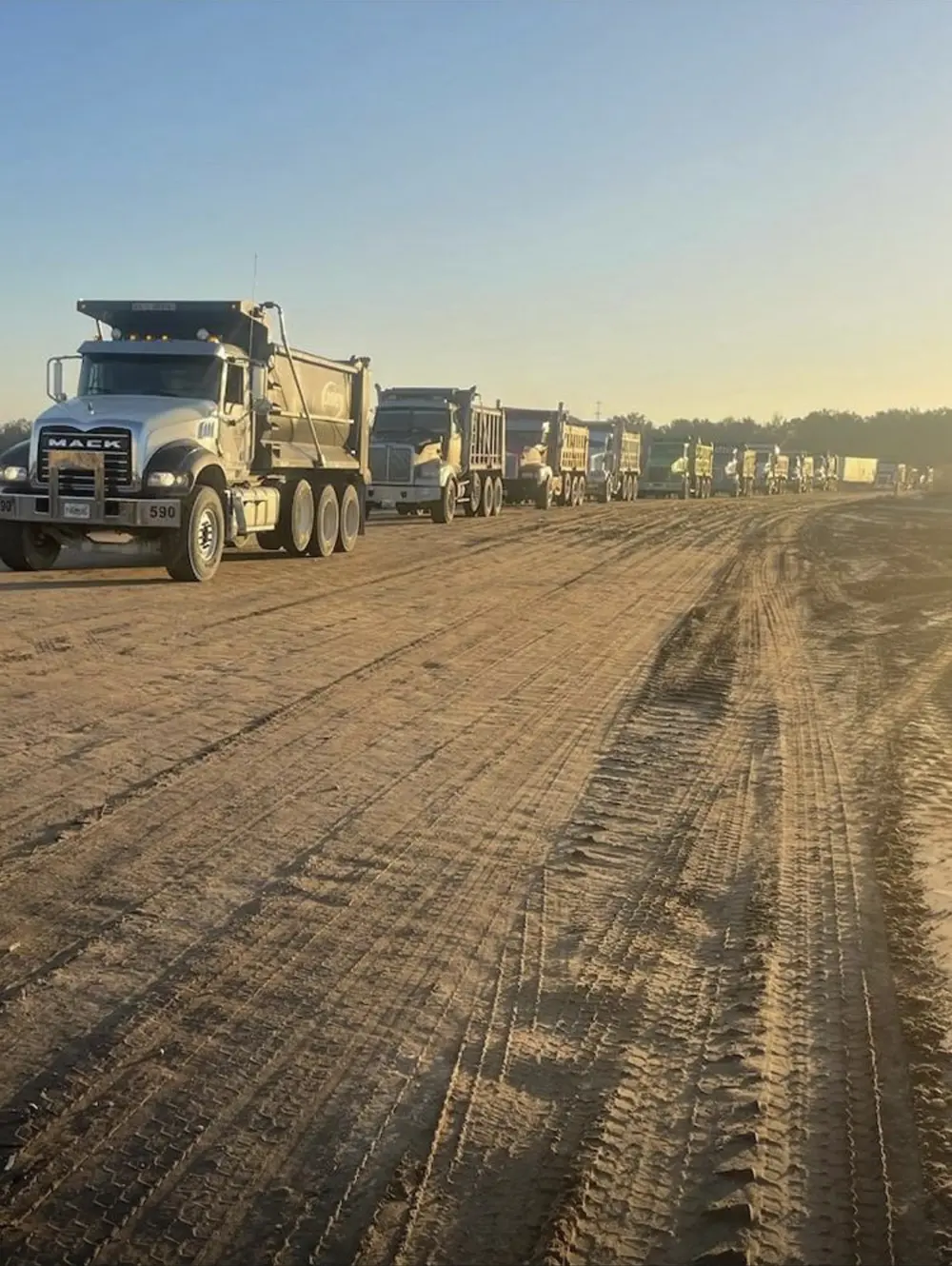 Tri-axle dump trucks staged for hauling on a Florida milling project